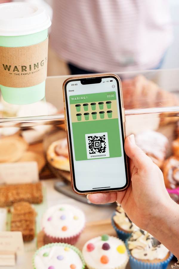 A customer showing the Waring’s loyalty card in their phone wallet at the bakery counter