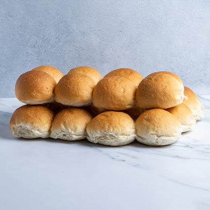 Stack of golden brown rolls on a marble surface with a light gray background