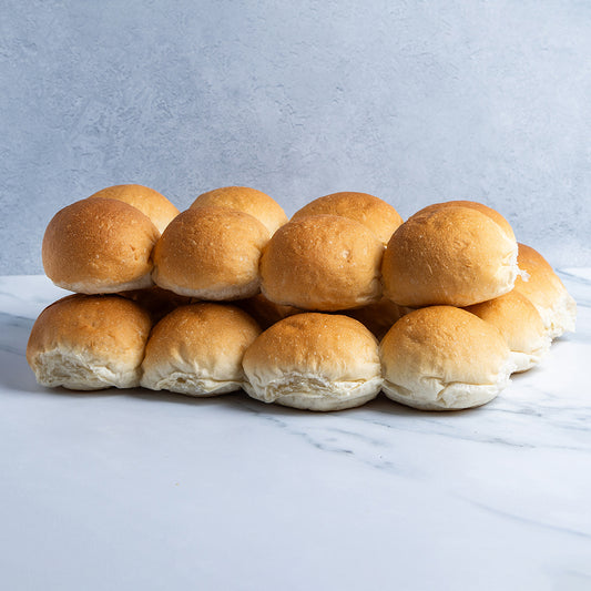 Stack of golden brown rolls on a marble surface with a light gray background
