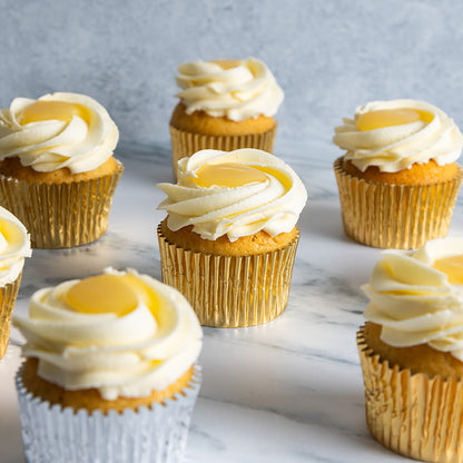 Cupcakes with white frosting and lemon curd on a marble surface