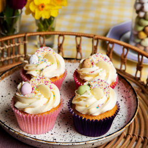 4 vanilla cupcakes with vanilla buttercream, each topped with a white chocolate jazzie, white chocolate button and a mini chocolate egg. Finally finished with a flurry of sprinkles.