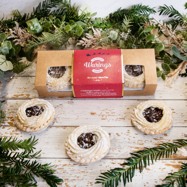 Six Viennese Mince Pies in a box with an additional 3 unboxed and displayed in front all surrounded by pine garland