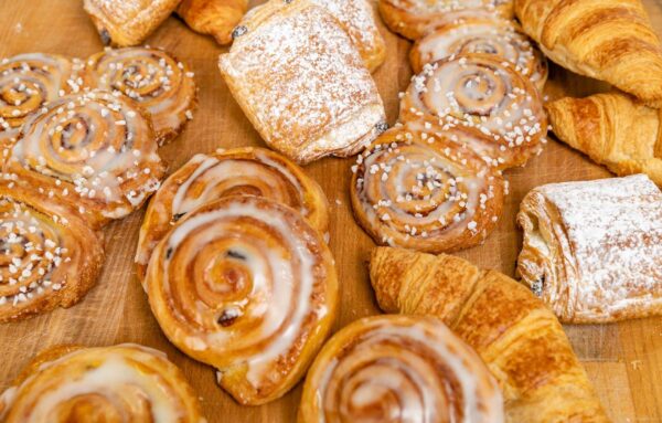 A freshly baked selection of pastries including lemon & fruit danish, pain au chocolat and croissants.