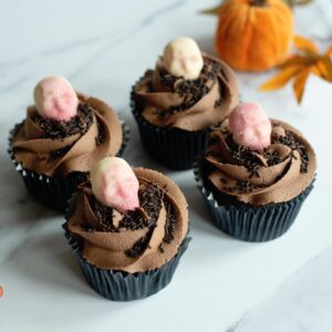 Chocolate Halloween cupcakes topped with white chocolate skulls and swirls of rich chocolate buttercream.
